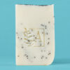 Savon blanc avec des morceaux noirs et motif végétal.