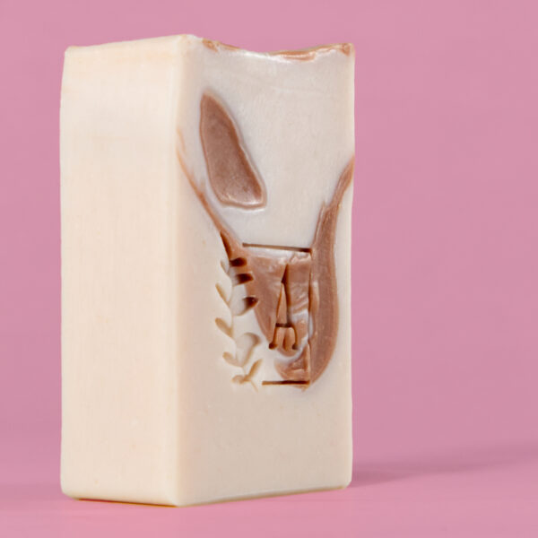 Savon artisanal avec motif sur fond rose.