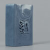 Savon bleu avec logo végétal en relief.