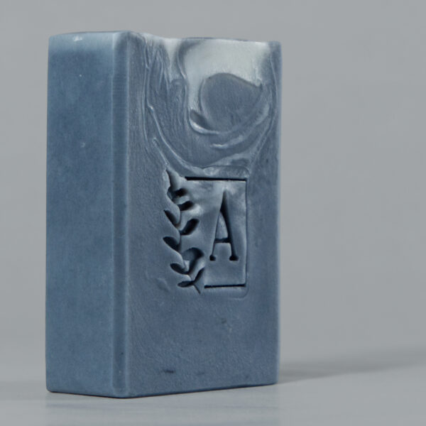Savon bleu avec logo végétal en relief.