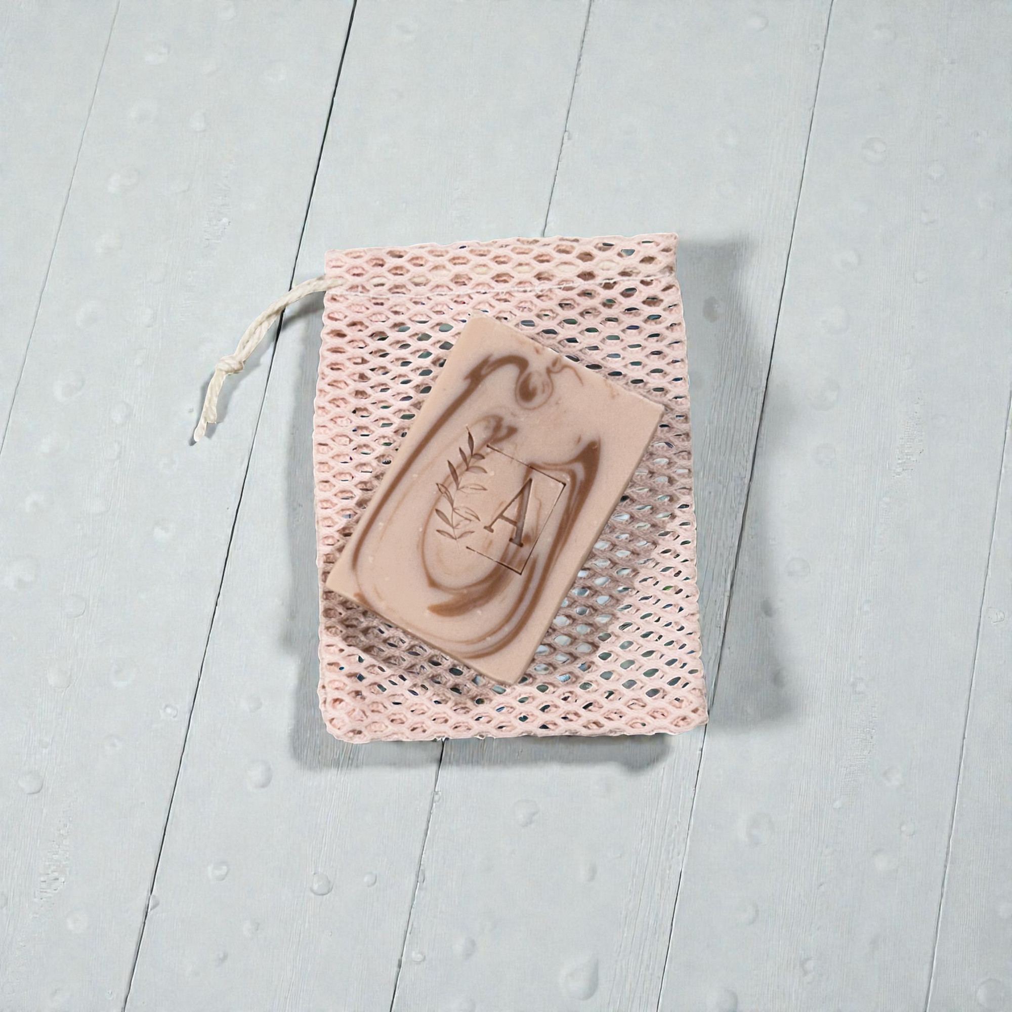 Savon naturel sur un sac en filet rose.