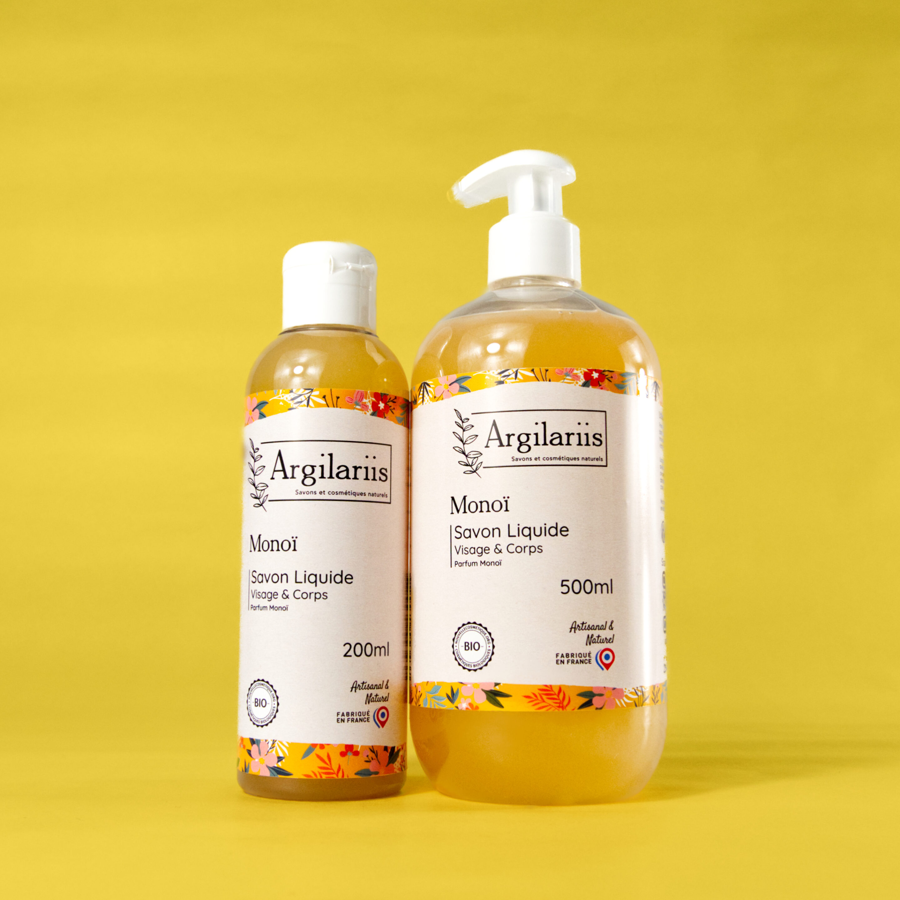 Deux bouteilles de savon liquide Monoi sur fond jaune.