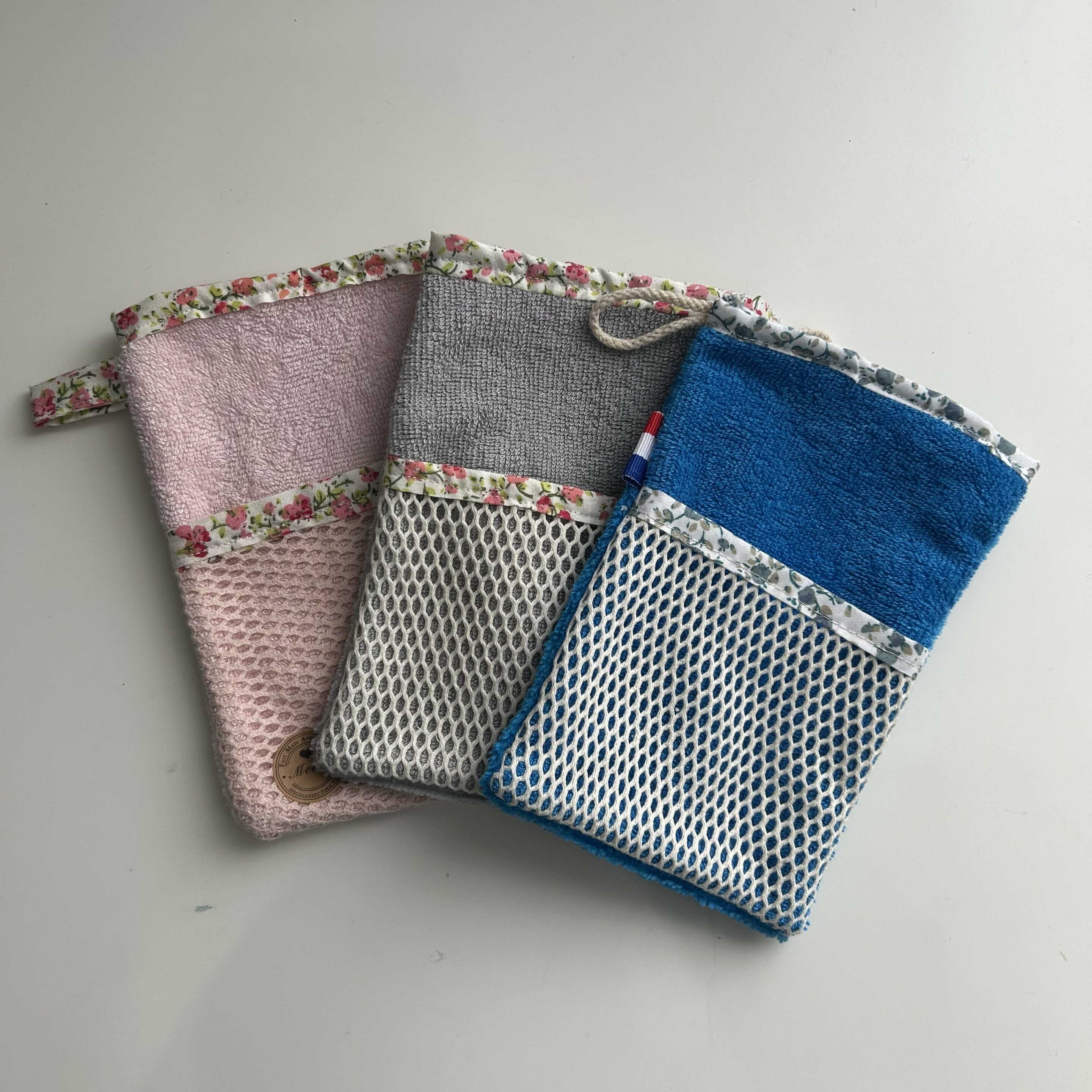 Trois pochettes colorées en tissu texturé.
